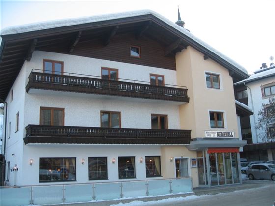 A charming building with a mix of wooden and plaster facades. The shutters and balconies give the house a traditional alpine style.