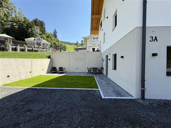 Modern nieuwbouwhuis met een ruime privé buitenruimte, zonnig terras, verzorgde gazon, gezellige zithoek en ligstoelen, evenals 2 parkeerplaatsen.