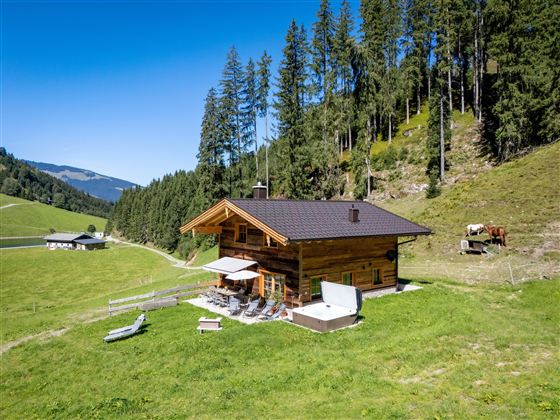 Hausansicht mit Terrasse, Liegewiese und Whirlpool Chalet Heualm - Kelchsau Kitzbühler Alpen