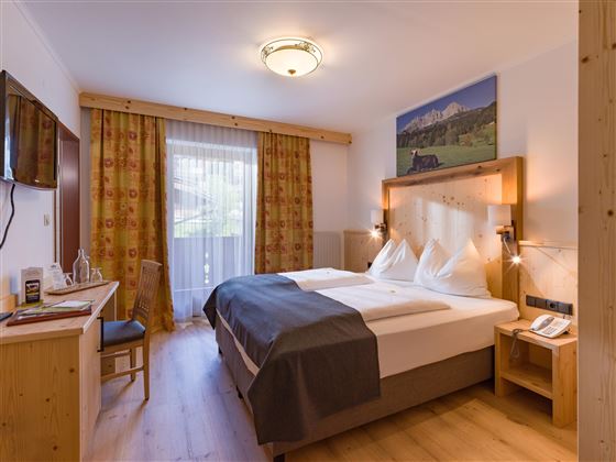 Doppelzimmer im Hotel Alpenpanorama in der Ferienregion Wilder Kaiser mit Holzakzenten, Schreibtisch und elegantem Lichtkonzept.