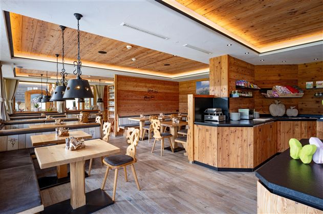 Een gezellig restaurant met houten meubels en warm licht. De inrichting is modern en uitnodigend.