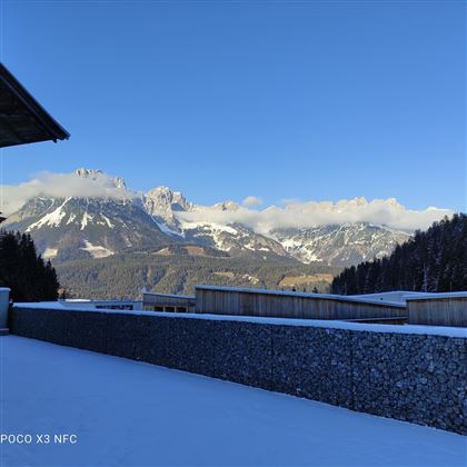 A winter landscape with snow-covered mountains and clear blue skies. The scenery is peaceful and picturesque, perfect for nature lovers.