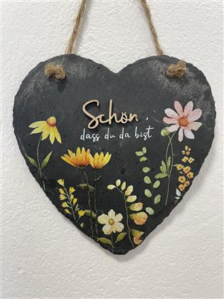 Een hartvormig bord van leisteen met kleurrijke bloemmotieven. Daarop staat de tekst "Mooi dat je er bent".