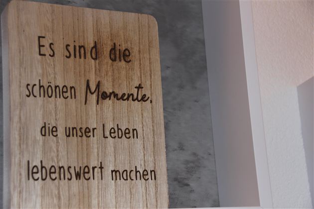 Ein Holzschild mit der Aufschrift: „Es sind die schönen Momente, die unser Leben lebenswert machen.“