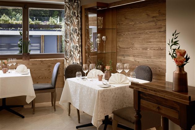 An elegant restaurant with neatly set tables and stylish decor. Large windows ensure plenty of light and a pleasant atmosphere.