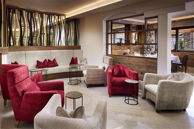 An elegant lounge area with comfortable red and beige armchairs. The warm atmosphere invites you to relax.