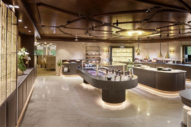 An elegant room with modern design and softly lit shelves. The focus is on a round table that displays various products.