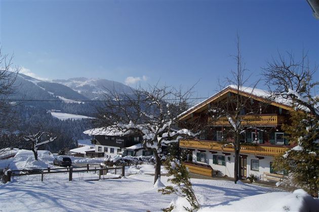 A picturesque winter landscape with snow-covered mountains and traditional wooden houses. The scene exudes tranquility and idyll.