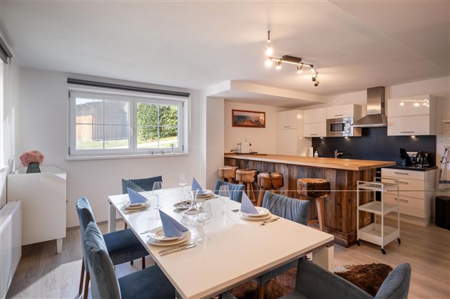 Wunderschönes Esszimmer mit Blick auf die Bar aus Altholz und moderner Küche