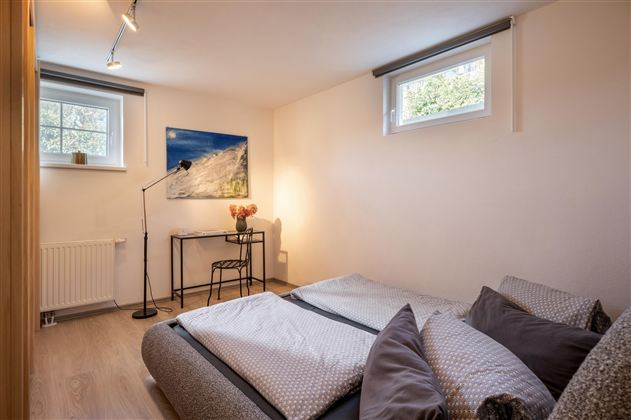Flauschiges und modernes Schlafzimmerbett mit großem Schrank für das gesamte Reisegepäck und kleinem Arbeitstisch.