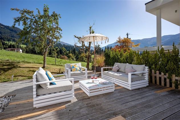 Einzigartige große Holz-Terrasse mit unverbautem Ausblick in die umliegende Berglandschaft. Moderne Terrassenmöbel, die zum Entspannen einladen und den ganzen Tag Sonne bieten. 
Die Talstation der Choralmbahn ist fußläufig in nur wenigen Gehminuten erreichbar.