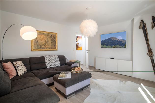 Großzügiges und modernes Wohnzimmer mit der Möglichkeit die Wohnzimmercouch in eine Schlafcouch für zwei Personen zu verwandeln.<br/>Ein großer Wohnschlafraum gewährt Ausblick in die bezaubernde Berglandschaft von Westendorf und bietet auch die Möglichkeit für einen entspannten Fernsehabend mit einem Sony OLED Flachbildfernseher.