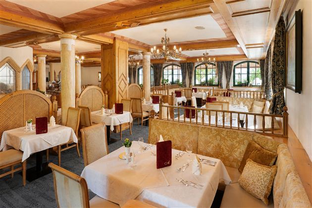 Ein elegantes Restaurant mit Holzverkleidung und stilvollen Tischen. Die Tische sind schön gedeckt und bieten eine gemütliche Atmosphäre.