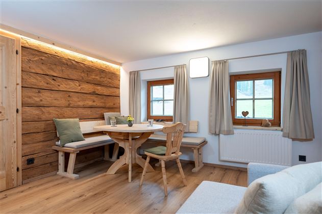 A cozy dining area with wood paneling and large windows. The room is bright and inviting, perfect for social hours.