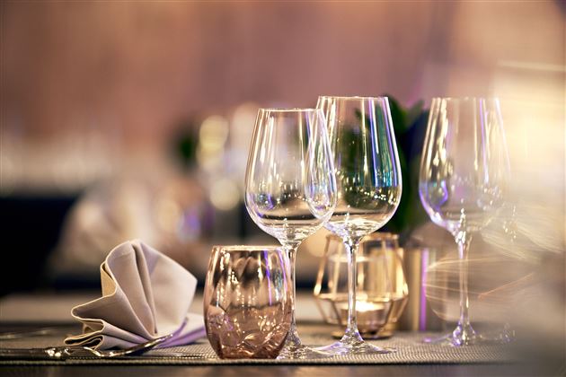 An elegant table with glasses and a folded napkin. Soft light creates a festive atmosphere.