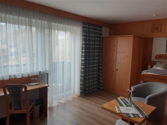 Ein helles Zimmer mit großen Fenstern und modernen Möbeln.