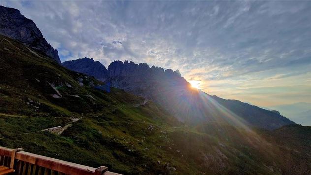 Een adembenemend bergzicht met zonnestralen die door de wolken schijnen. De bergtoppen zijn op de achtergrond duidelijk zichtbaar.
