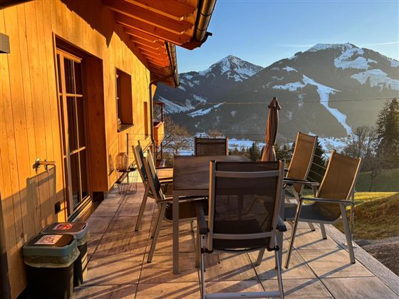Eine gemütliche Terrasse mit Stühlen und einem Tisch bietet einen schönen Ausblick auf die Berge.
