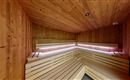 A peaceful sauna with wooden walls and cozy benches. It offers a relaxing space for resting and feeling good.