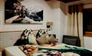 A cozy bedroom with a large bed and wooden ceilings.  
A decorative picture hangs on the wall, and the decor is modern and inviting.