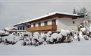 A snow-covered house in an idyllic winter landscape. Surrounded by snow and trees, the scene radiates serenity and coziness.