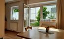 Das großzügige Wohn- und Esszimmer überzeugt mit viel Tageslicht, einer gemütlichen Atmosphäre und direktem Zugang zur Terrasse. Der Essbereich lädt zu gemeinsamen Mahlzeiten ein, während die großen Fenster einen schönen Blick ins Grüne bieten – der ideale Ort zum Entspannen und Wohlfühlen.
