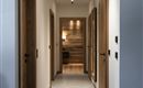 A modern corridor with wooden and white walls. Doors on both sides lead to different rooms.