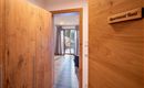 An inviting hallway with wooden panels that leads to a cozy apartment. A sign reads "Apartment Hans".