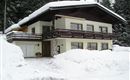 A charming house in the snow with a large balcony.  
Surrounded by snow-covered fir trees.