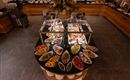 A buffet with a variety of dishes in elegant bowls. The selection includes fresh fruit, vegetables, and other delicacies.