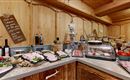 A buffet with various types of meat and fresh ingredients in a rustic setting. The wood look creates a cozy atmosphere.
