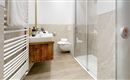 A modern bathroom with a shower and a wooden shelf. The walls are designed with bright tiles and a wood look.