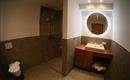 Een moderne badkamer met douche en wastafel. De muren zijn in neutrale kleuren gehouden en er is een gezellige sfeer.