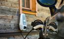 Ein Elektroauto wird an einer Ladestation aufgeladen. Im Hintergrund ist ein Holzhaus mit einem Fenster zu sehen. 
Chalet Heualm Kelchsau Kitzbüheler Alpen