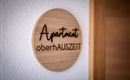 Een houten bord met de tekst "Apartment oberhAUZSEIT".