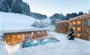 A beautiful winter resort with an outdoor pool, surrounded by snow-covered trees. The atmosphere is calm and inviting.