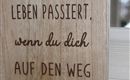 Ein Holzschild mit inspirierendem Spruch. Der Text ermutigt dazu, aktiv zu werden und den eigenen Weg zu gehen.
