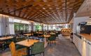 A modern restaurant with bright wooden paneling and comfortable seating. Large windows let in plenty of light and offer a view of the outdoor areas.