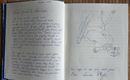 Een open notitieboek met handgeschreven tekst aan de linkerkant en een tekening van een liggende kat aan de rechterkant. De pagina toont persoonlijke berichten en creatieve illustraties.