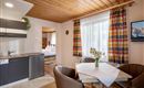 A cozy holiday apartment with a small kitchenette and a dining area.  
Large windows provide bright light and a pleasant atmosphere.
