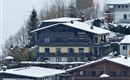 A picturesque building in the snow with a traditional alpine style. Surrounded by trees and a tranquil winter landscape.