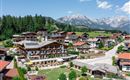 Luftaufnahme des Hotels Alpenpanorama mit umliegender Berglandschaft und Sonnenterrasse.