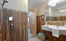 Helles Badezimmer im Hotel Alpenpanorama in der Ferienregion Wilder Kaiser mit Dusche, Waschbecken und hochwertigen Details.