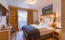 Doppelzimmer im Hotel Alpenpanorama in der Ferienregion Wilder Kaiser mit Holzakzenten, Schreibtisch und elegantem Lichtkonzept.