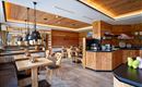 Een gezellig restaurant met houten meubels en warm licht. De inrichting is modern en uitnodigend.
