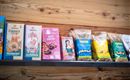 Een rek met verschillende verpakkingen snacks en zoetigheden. De verpakkingen zijn kleurrijk en aansprekend ontworpen.