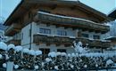 A cozy chalet in winter with fresh snow. The balconies are made of wood and the surroundings are picturesque.