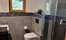 A modern bathroom with a shower and a toilet. The walls are in neutral colors, and a window provides natural light.