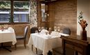 An elegant restaurant with neatly set tables and stylish decor. Large windows ensure plenty of light and a pleasant atmosphere.