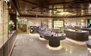 An elegant room with modern design and softly lit shelves. The focus is on a round table that displays various products.